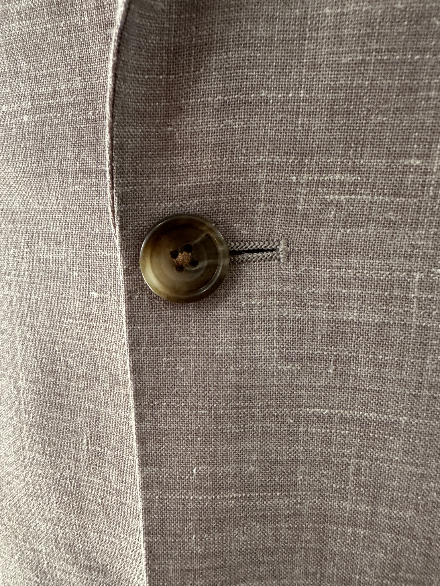 Close view of cable-knit texture and horn buttons